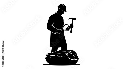 A man in a hard hat examines a rock with a hammer in hand standing on a large stone