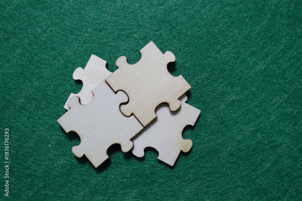 Obraz premium Three wooden puzzle pieces on a green surface