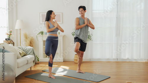 Asian man and woman train balance and stability with yoga exercise, supporting healthy lifestyle at home