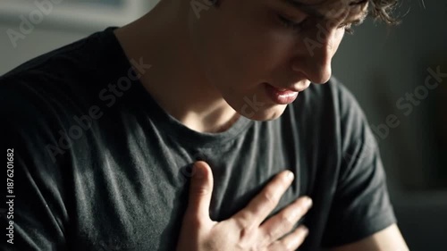 Wallpaper Mural Young Man Holding Chest Experiencing Anxiety Or Heart Pain Indoors Torontodigital.ca