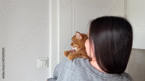 Girl brunette dancing with cute orange domestic cat cat at home