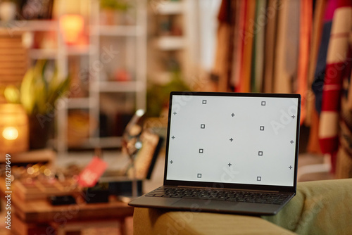Konstfotografi Open laptop displaying calibration screen standing on sofa in second hand shop,