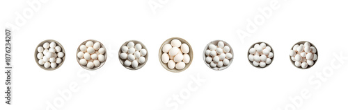 Variety of small white objects in metal containers on white background