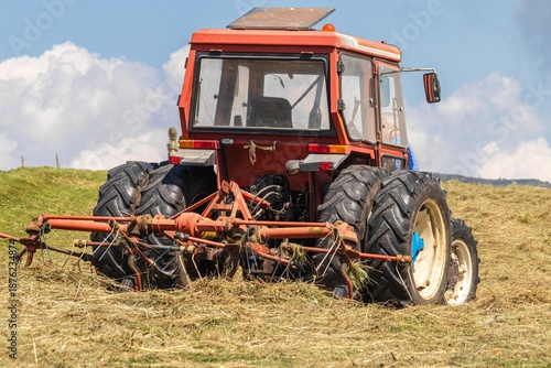 Bilde på lerret Red tractor with attached hay tedder