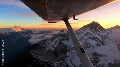 Breathtaking aerial view of snowy mountains at sunset from airplane window