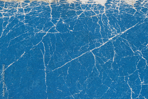 Texture of old shabby book cover close up. Blue cracked paper texture with organic white veins and worn top edge. Natural background texture