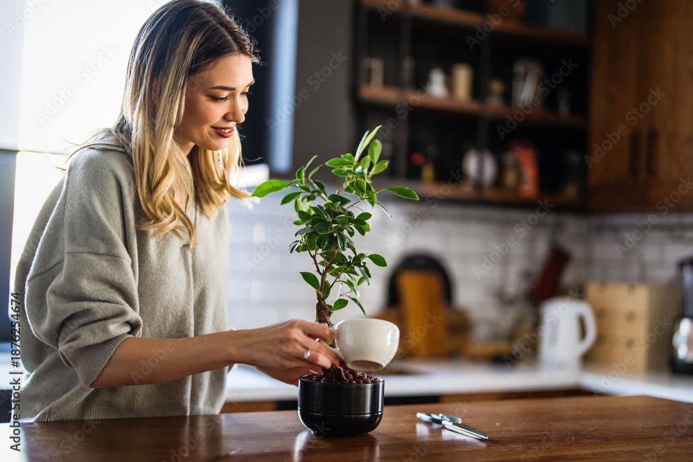 Naklejka premium A woman trimming indoor plants, enjoying home gardening and relaxation at home, peaceful weekend