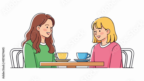 Two smiling young women with different hair colors sit at a table with coffee cups
