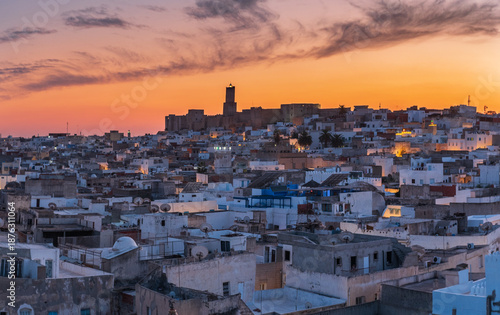 Sunset view over the historic medina of Sousse, Tunisia, with dense urban rooftops and warm evening light, evoking culture, tradition, everyday city life, and North African atmosphere