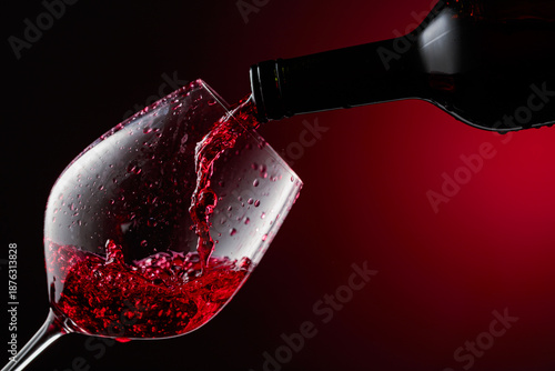 Red wine is poured from a bottle into a glass.