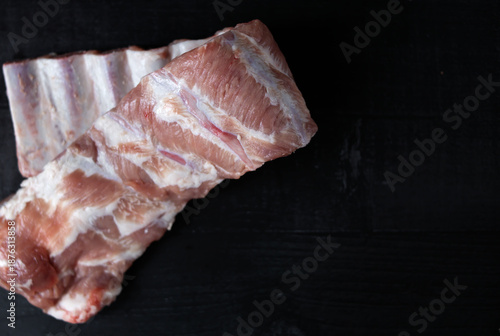 Fresh pork ribs. Lying on a table with a black background. Food