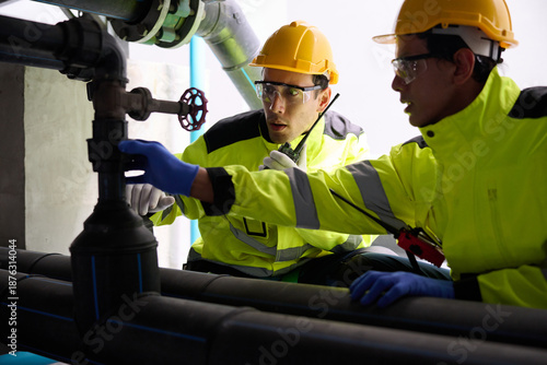 Картината върху платно Engineers talking on walkie talkie and inspecting industrial pipelines, ensuring