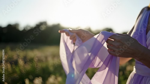 Woman Holding Lilac Chiffon Fabric in Sunlight