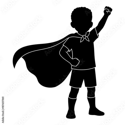 Silhouette of powerful young boy standing bravely wearing a flowing superhero cape