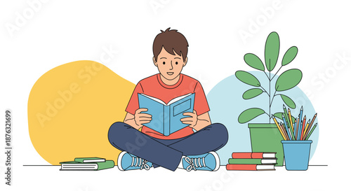 Young boy sitting cross-legged on the floor and reading a book while surrounded by his school supplies and various books.