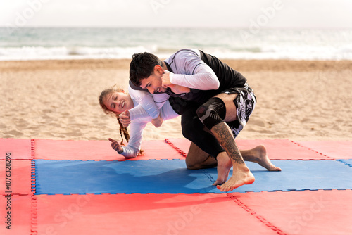 Photos Friends grappling jiu jitsu on beach mat