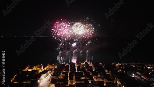 Aerial view of Lazise, Lake Garda, Italy, during fireworks on August 24, 2025. Drone footage captures the historic center, lakeside town, evening lights, and summer celebration in 4K.