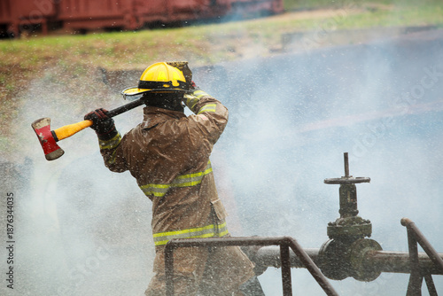 Firefighter operating industrial valve during emergency response