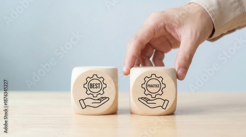A hand places a wooden cube with the word practice on a light table next to a cube with the word best symbolizing successful business strategies and efficient processes