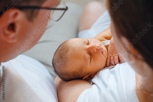 New parents hold their baby close in a home setting