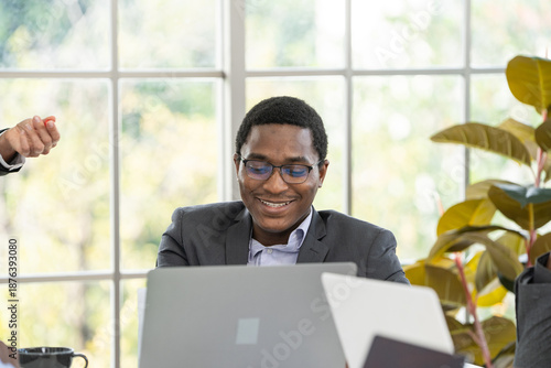 black business man smiling while working at laptop