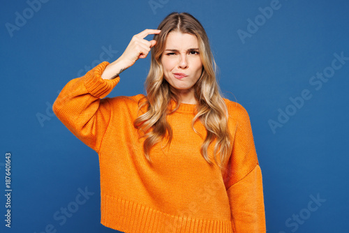 Foto Young sad frustrated mistaken thoughtful woman she wears yellow sweater casual clothes put hand on head look aside on area mockup isolated on plain blue background studio portrait