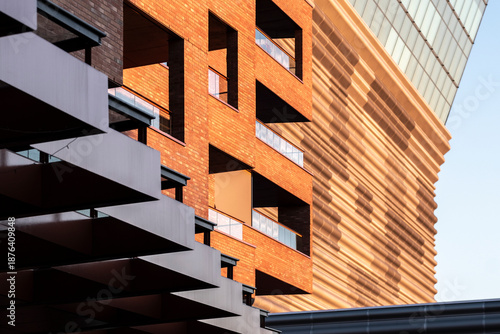 Modern urban architecture with a brick building facade where geometry and pattern meet deep shadow and warm sunlight for minimal abstract texture