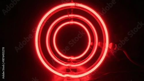 Glowing red circular neon light elements against dark background