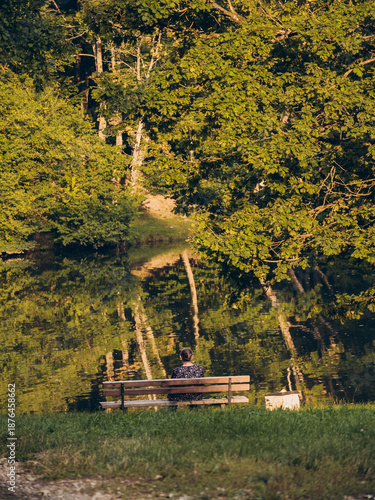 A lonely woman sits on a bench in a park