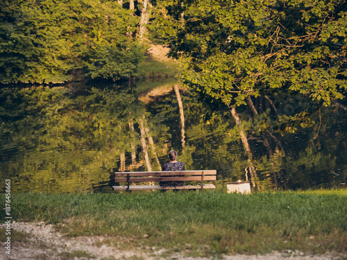 A lonely woman sits on a bench in a park