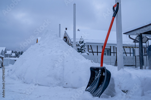 Εκτύπωση καμβά Snow shovel standing near large pile of snow on roadway outside private house