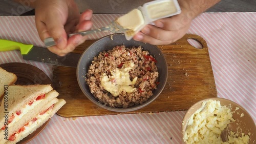 A man prepares tuna and egg sandwiches for lunch.
