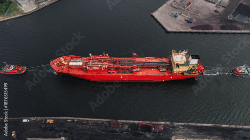 LPG tanker escorted by tugboats on calm sea waters, maritime transport, industrial shipping, logistics, and port operations concept.