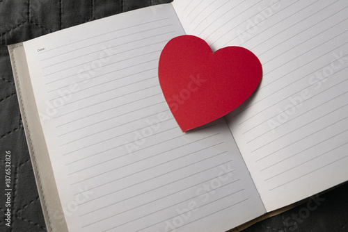 Hand cut heart from red paper on a notes