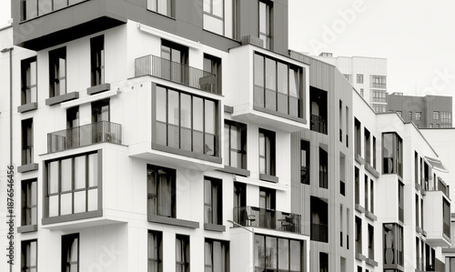 Modern residential apartment building with balconies and curved facades in an urban city setting.