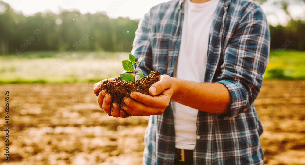 Εκτύπωση καμβά A farmer kneels with a new plant before planting it in a field