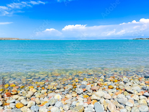Scenic Ocean View with Colorful Pebble Beach Under Clear Blue Skies. Bishkek, Kyrgyzstan