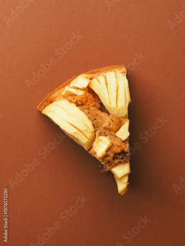 A slice of organic whole grain apple pie on a brown background, viewed from above