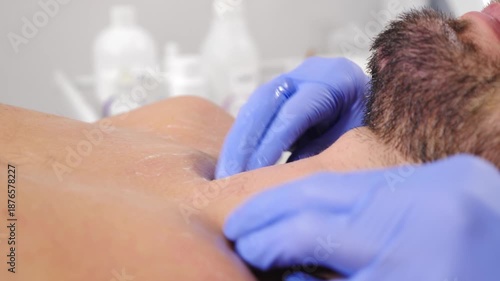 Handsome man enjoying neck massage in spa center. Relaxed male client lying on bed in beauty parlor as masseur rubbing skin. therapist making client athlete neck massage in spa salon. Professional