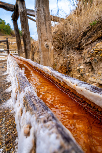 Fotografie Anana salt flats brine flowing along wooden channel