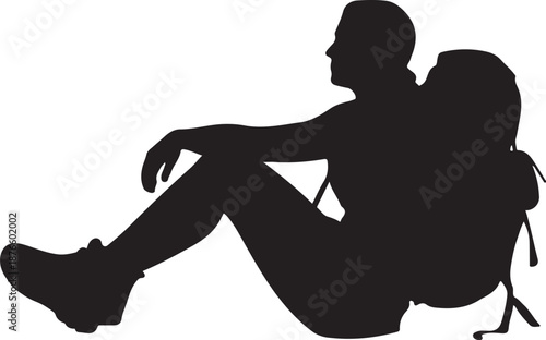 Silhouette of person sitting with backpack on ground