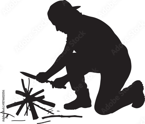 Silhouette of person starting a campfire with a knife