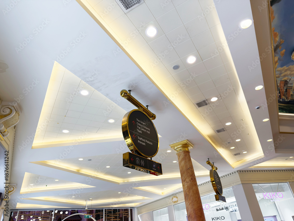 Fototapeta premium Interior shopping mall ceiling with warm lighting and decorative sign in Manchester UK