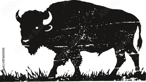 Black bison silhouette walking on grass with textured vintage and distressed effect