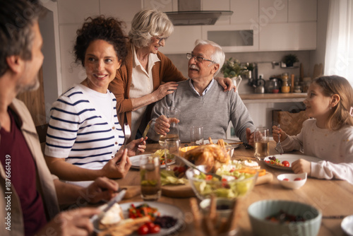 Foto Multi-generational family members enjoying lunch together at home