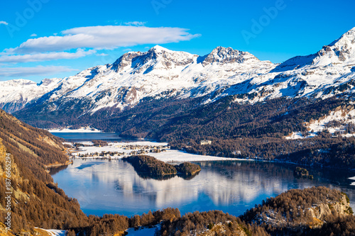 A view of Lake Sils and the Chaste peninsula from above. Panorama from Grevasalvas in winter.
