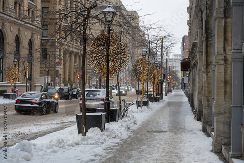 Winter traffic scene in a snowy street in Old Montreal during a snowfall covering roads and vehicles