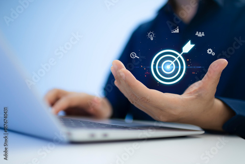 Businessman with laptop holding target icon and arrow, symbolizing goal setting, focus, vision, and business success. Ideal for leadership, strategy, planning, and marketing concept