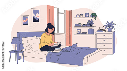 Student sits comfortably on her bed while using a laptop and taking notes in a notebook for her online learning studies.