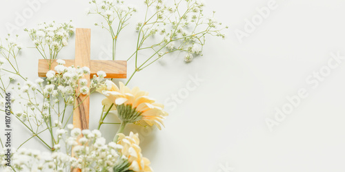 Christian Cross with White Gypsophila and Yellow Gerbera Flowers on Light Blue Background With Copy Space. Concept of Easter Celebration, Palm Sunday, Religious Holidays, Grace and Spring Renewal